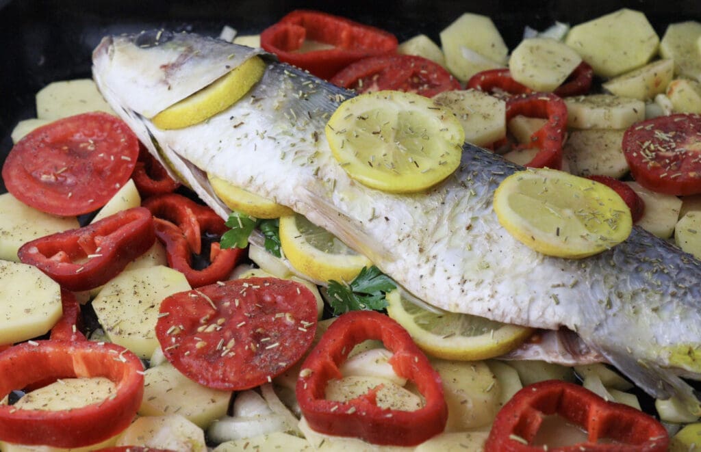 Image showing how to season everything with dried rosemary before baking the mullet.